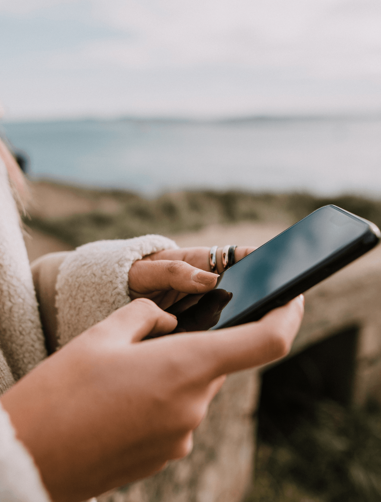 someone using an iPhone at the beach