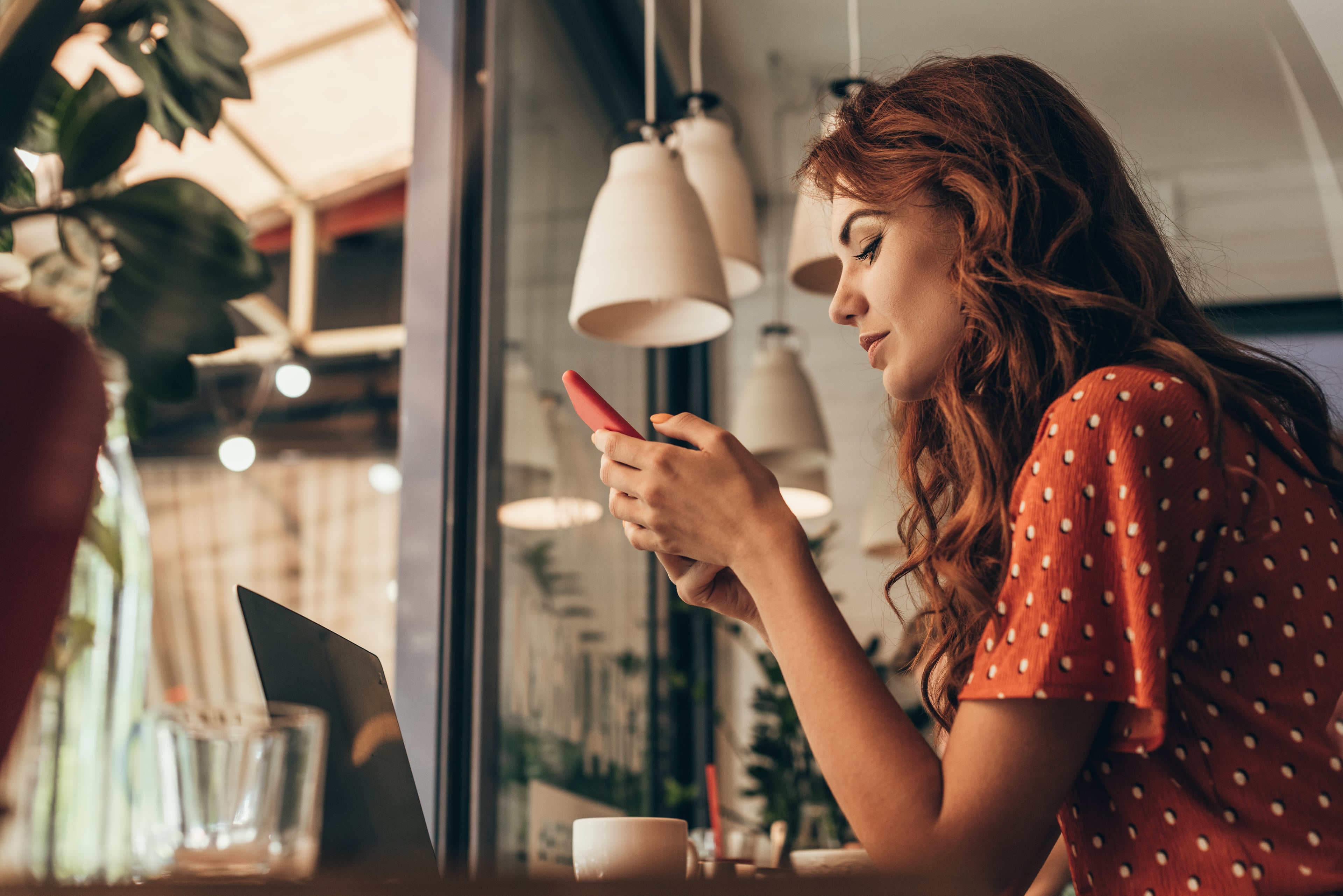 girl scrolling through phone whilst in coffee shop in norwich